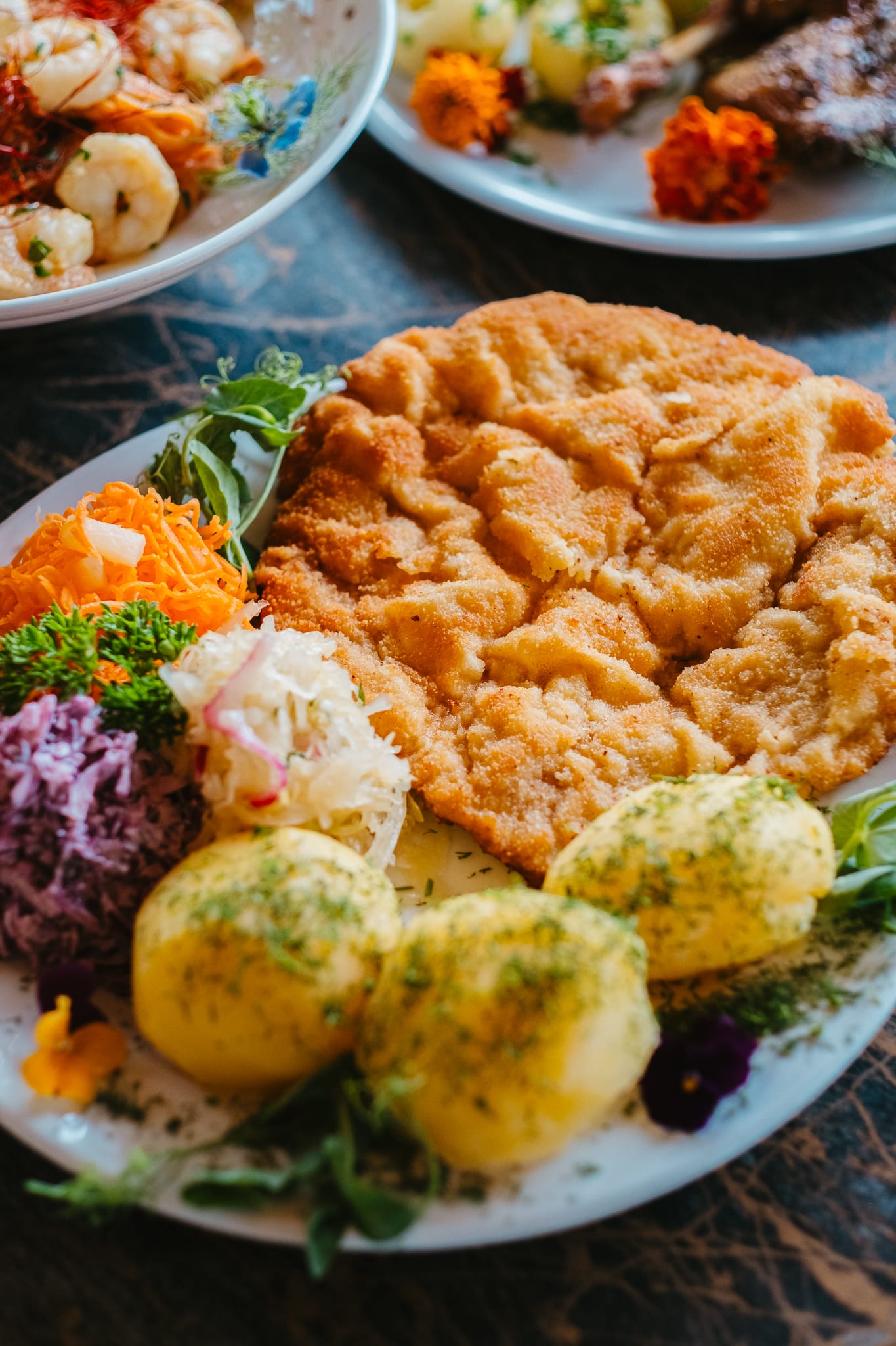 Duży kotlet schabowy z ziemniakami i zestawem surówek